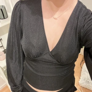 Svart blus  - Säljer denna blus från bikbok, materialet kan upplevas som glittrigt k vissa ljus vilket är väldigt fint, det är blus material på den, hör av er vid frågor ❤️