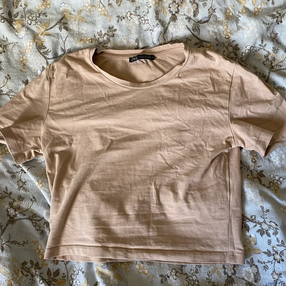 En söt typ aprikosfärgad/beige t-shirt från zara! Köpt förra året och har knappt kommit till användning🩷. T-shirts.