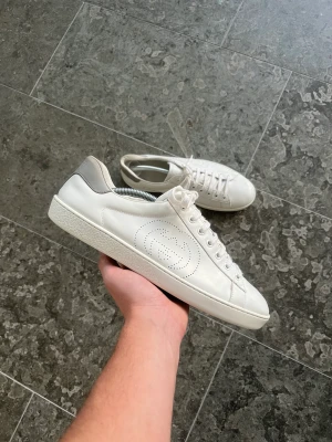 Gucci ”ace” sneakers - Säljer dessa gucci ace sneakers! Skick 9/10, väldigt fina. Storlek 42,5, sitter som 43. Pris 2200kr.  Inget og medföljer, endast skorna  Vi garanterar alltid äkthet på våra produkter, därav är denna vara noggrant kontrollerad.