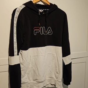 Svart/Vit Hoodie Fila stl. M - En vit och svart hoodie från Fila. Storlek Medium. Den är i bra skick.