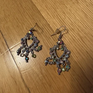 örhängen med olika färgade rihnestones  - en sten/ rihnestone är av men syns inte mycket, är rengjorda och inte använda så mkt