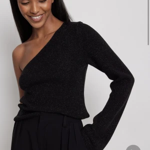 Glittrig topp - Glittrig svart topp med en arm från Nakd! Nypris 549kr, slutsåld på hemsidan!