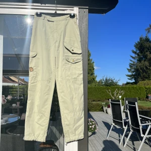 Högmidje fjällräven byxor  - Säljer mina fjällräven grå/beige byxor! Köpt i andra hand men var för så för mig! Är en vintage modell från Finland, högmidje och skönt material. Enstaka små 1mm fläckar men knappt synliga, så därav priset. Är storlek 38 men skulle säga passar 36 också 🫶🏼