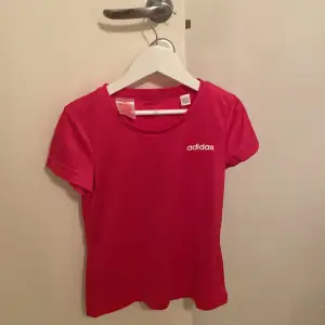 Detta är en rosa tränings t-shirt, den har en vit text där det står adidas på! I ett väldigt bra skick 
