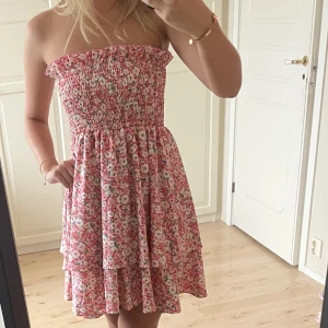 Blommig klänning - Söt klänning i blommigt, ribbat material upptill och volanger nertill använd fåtal gånger!💞