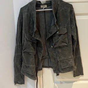 Camouflage tröja - En camouflage tröja som kan även funka som en jacka till våren. Den ger även lite känsla av 2000-talet. Den går också att göra smalare i midjan 