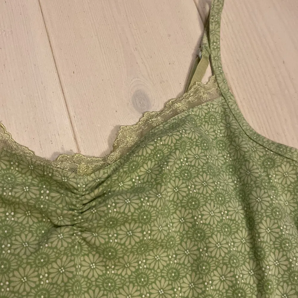 Ett väldigt gullig grönt linne från Lindex, Inte använd mycket. Skönt material med fin spets. Har även inspännbara band . Toppar.