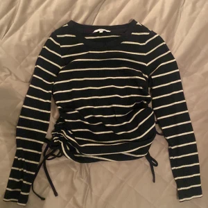 Next tröja - Snörningar på sidorna av tröjan som gör den justerbar. Och det går o välja passform. Den är marinblå med benvita sträck om det inte syns på bild. Slutsåld