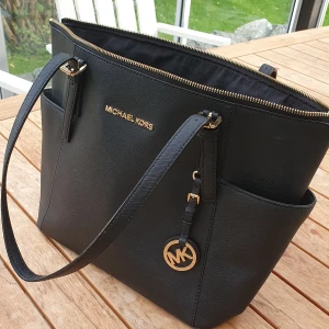 Michael Kors Handväska - Väskan är rymlig, ca 37x27 cm. Det är en äkta MK. Den är några år gammal men i fint skick. 
