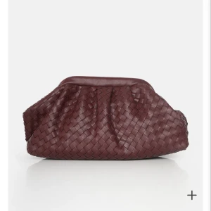 Clutch väska - Intressekoll!! As snygg clutch väska som både kan användas som clutch och väska. Den är vinröd/burgundy och flätad. Påminner om Bottega, men kommer från ett brittiskt märke. Rymlig och banden går att justera samt ta av❤️ Använd 3 gånger