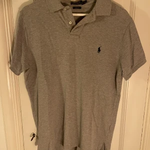 Grå piké från Ralph Lauren - Grå piké från Ralph Lauren i storlek M. Fint skick!