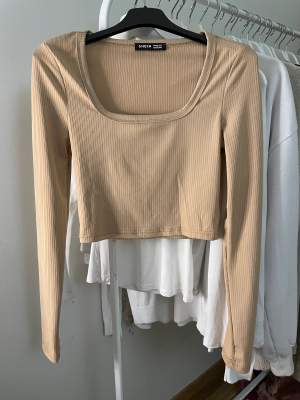 Beige eller senaps gul urringad långärmad kort topp i storlek XS.  