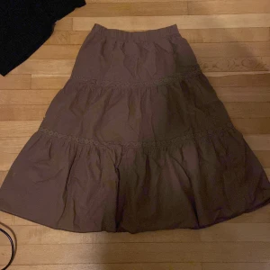 lång brun kjol - säljer denna fina bruna kjolen ifrån romwe! kjolen når ner en bit under mina knän och jag är runt 163. vet ej varför den ser grön ut på vissa ställen på bilderna men den ser inte ut så i verkligheten! 🫶