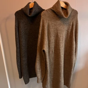 Två tröjor i lång modell - Två superfina stickade tröjor från VILA. Dock är alla lappar inne i tröjan bortklippta. Bra skick! Den grå är lite kortare än den bruna. Båda i storlek M.