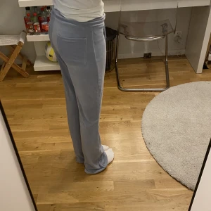 Velour byxor från Gina tricot  - Mysbyxor i velour med fickor bak. Byxorna är ljusblåa och har en mjuk resår i midjan med snöre där fram.