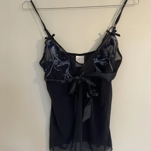 Topp med mesh och fina sömmar - Fin topp, knappt använd. Banden går att justeras