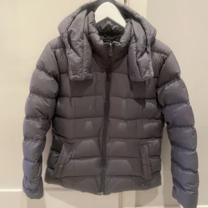Polo Ralph Lauren dunjacka - Tja säljer en ny superfin grå Polo Ralph Lauren vinterjacka! Säljer den pga ett felköp. Den är en dam modell så den har dam storlek och är lite insvängd vid kurvorna. För frågor och funderingar kan du kontakta mig. 