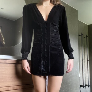 Svart Sammet klänning  - Säljer denna då den bara kom till användning en gång, sammet klänning i svart med knappar i mitten. Skit snygg 