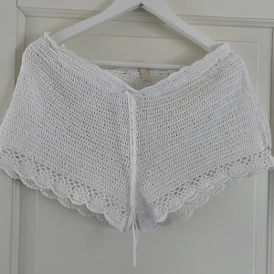 Vita virkade shorts H&M - Vita virkade shorts från H&M, korta med knytning i midjan. Inköpta i London, strl 12 och passar bäst strl S.