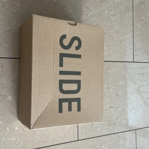 Yeezy slidea - Säljer ett par helt oanvända yeezy slides i färgen beige brown. Har legat i garderoben ett tag nu och vill få de sålda snabbt, först till kvarn får skorna. 