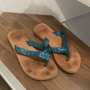 Sandaletter med blåa paljetter  - Super gulliga sandaletter med blåa paljett detaljer. Använda några gånger, men i fortfarande fint skick
