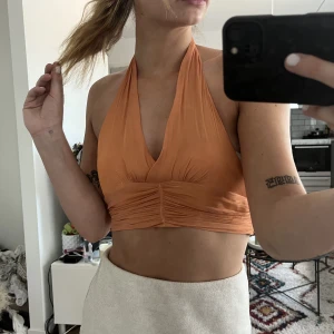 Orange knyttopp - Superfin orange topp som man både kan ha en vanlig sommardag som till fest. Det är en storlek M men sitter som en S.