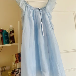 Nytt Ljusblått linne volang L/XL Copenhagen Lux - Supersnygg linne med volang i axelbanden. Färg: ljusblå. Storlek XL men mer en L. Märke Copenhagen Lux. Nypris 499:-