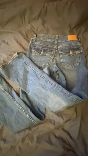 Mörkblå lågmidjade bootcut jeans i st 34 från ginatricot använda fåtal gånger. Säljs för att dom har blivit för korta!