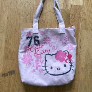 Hello Kitty väska - En väska som är köpt här på Plick. Använd fåtal gånger men är supergullig!💗💗cirka 25 cm på bredden, 29 cm på längden utan handtagen och 24 cm på handtagen💗