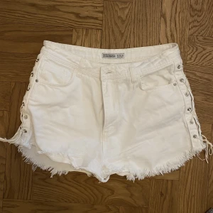 Jeansshorts - Vita jeansshorts med detaljer på sidorna. Knappt använda.