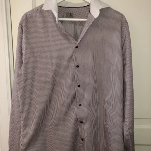 Randig skjorta - Blå,röd,vit randig seidensticker skjorta med vit krage. Mycket bra skick, använt ett fåtal gånger.