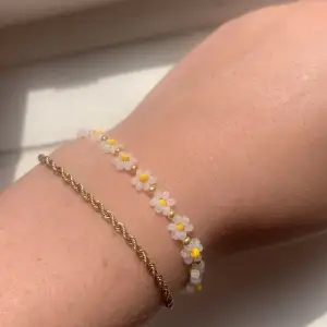 Ett vitt blommigt armband gjort av pärlor. 