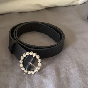 Bälte - Ett svart bälte med diamanter på spännet 