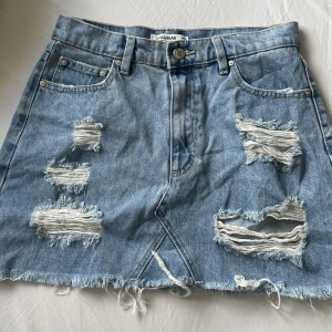 Jeans kjol - Super fin jeanskjol med slitningar från pull&bear i storlek M. Kjolen är sparsamt använd och i jätte fint skick. Tveka inte på att höra av dig om intresse finns eller för fler bilder☺️
