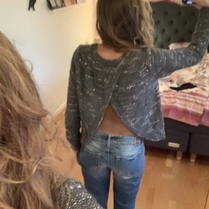 Öppen rygg  - Stickad tröja med öppen rygg. Tröjan är grå med silvertråd⭐️