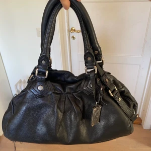 Marc Jacobs väska - Snygg och tuff väska från Marc Jacobs i modell The Baby Groovee & storleken M. Passar perfekt till alla outfits och rymmer mycket. Använts några gånger men fortfarande i superbra skick pga gjord av tåligt läder💕  Nypris ca 6000kr, skriv för fler bilder!🫶