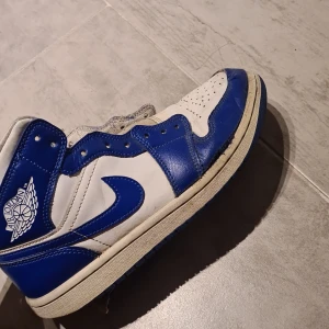Jordan 1 mid kentucky blue - Lite i sönder på toeboxen men går och sy om köpte dem för 2600 på kicks and stuff lite smutsiga men man kan tvätta storlek 38 men passar mig och jag har storlek 41