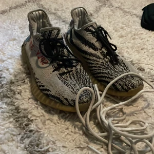 Yeezys skor - Skick: 1/10, Väldigt slitna, orginal snören finns men trasiga, äkta men finns ej någon box. Skriv vid intresse eller fler bilder på skorna!