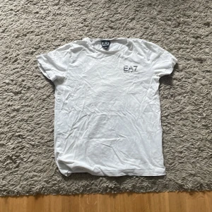 Vit EA7 T-shirt - En fin vit Emporio Armani T-shirt. Köpt från JD sports. Skick= 7/10. Storleken är XS.  Säljer för 150. 