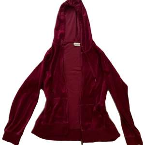 Vinröd zip-hoodie i sammetsliknande material, står XL på lappen men skulle mer säga M