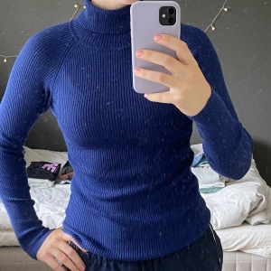 Blå Polotröja - Mörkblå och vibrant polotröja köpt på Cubus. Säljer då jag ej använder och använd ca 25 gånger. Ganska tjockt, ribbat material. Storlek XS men passar på mig som bär S-M och skulle nog fungera upp till XL - materialet är väldigt stretchigt. Org pris 200kr.