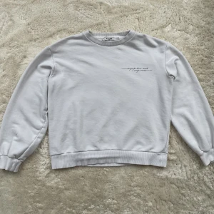 Vit Sweatshirt Nakd  - Säljer denna sweatshirten då den inte kommer till någon använding. Bra skick men trycket börjar bli utsuddat men inget större problem.