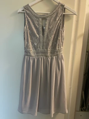 Klänning  - Grå klänning med paljetter upptill. Storlek small. 200:-