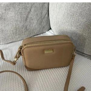 Beige axelremväska - Beige axelremväska i nyskick. Använd endast en gång.  