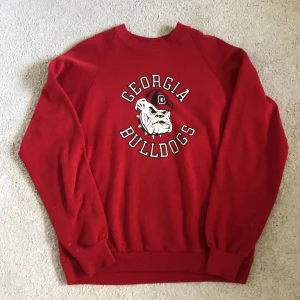 Vintage crewneck  - Röd vintage crewneck med print.  Fint skick förutom tre smä fläckar på vänstra ärmen och trycker är lite slitet pga att det är vintage