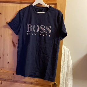 Hugo boss T-shirt  - Hugo boss T-shirt i storlek M. Tröja är i måttligt använt skick, det finns inga hål. Texten på framsidan har spruckit lite, vilket är det ända med tröjan. 