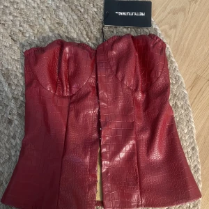 Oanvänd Skinn korsett  - En snygg röd oanvänd skinn korsett med lite ormskinns mönster😍 tyvärr är den för liten för mig. Fler bilder kan skickas privat❤️