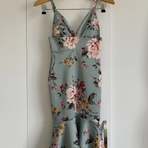 Blommig klänning - Blommig klänning i turkos/ljusblå är från NLY i st S, nyskick endast använd en gång på bröllop. Jätte fin passform, tajt med volanger nedtill. 