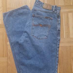 Säljer sonens Nudie jeans modell Tuff Tony i strl 30/34. Relaxed fit, hög midja, knappgylf. Använda ett fåtal gånger. Hämtas i Göteborg eller i Kungälv. Kan skickas om köparen betalar frakten.