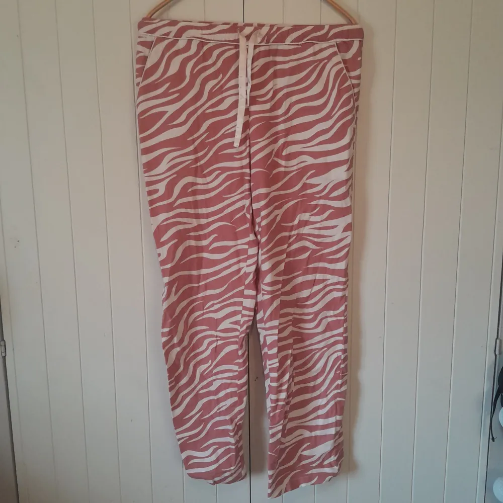 Rosa pyjamas byxor med vita tiger ränder. Dam storlek small/xs. Endast använd ett fåtal gånger och i bra skick! Hör av dig om du vill köpa tillsammans med skjortan!. Jeans & Byxor.